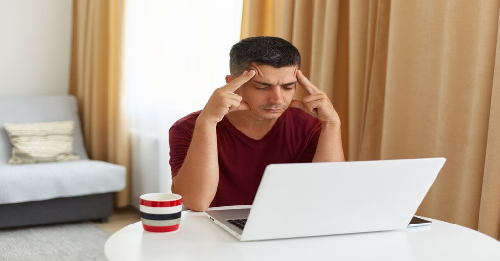man in stress in front of his laptop